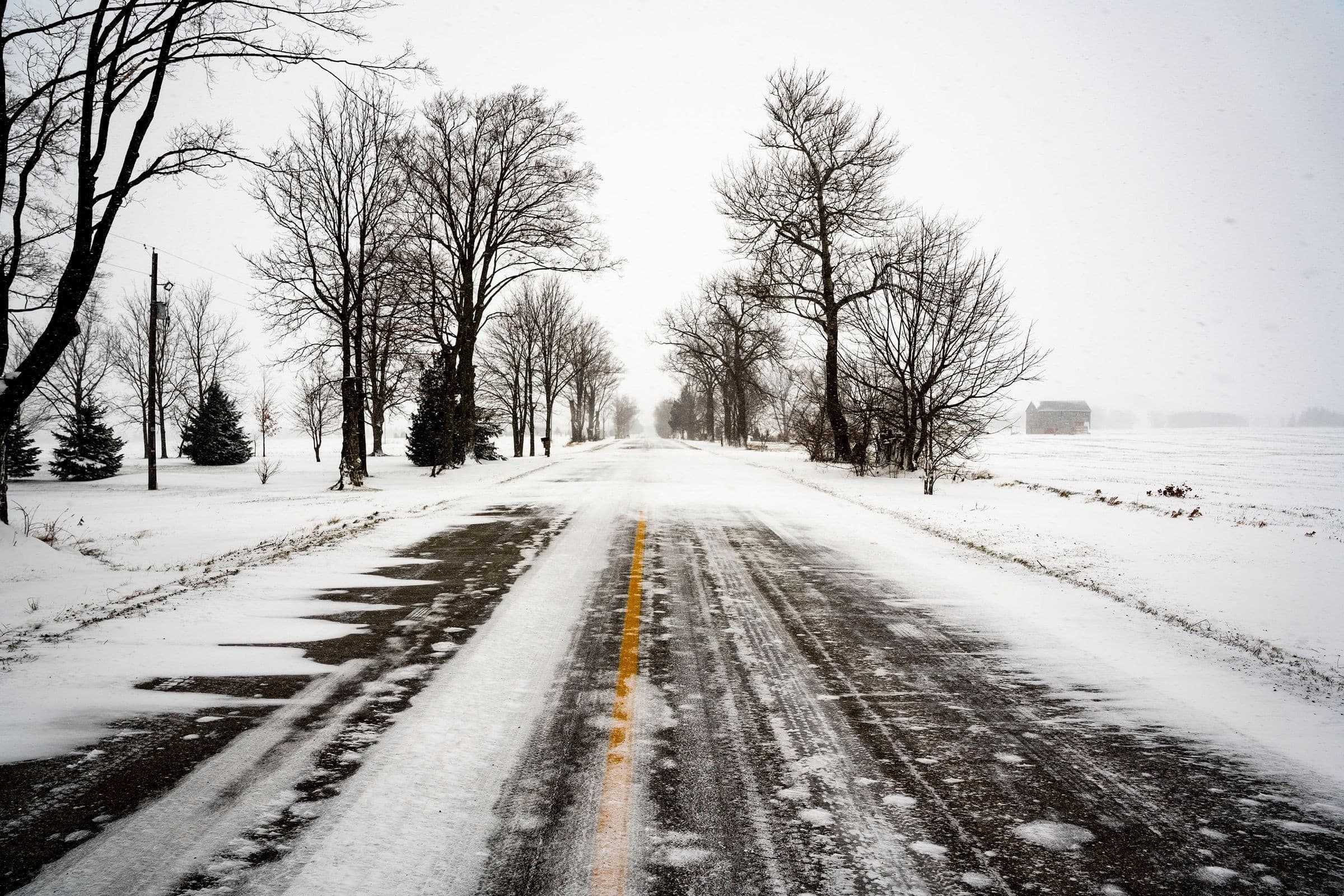 Winch out service Chillicothe IL: snow-covered rural road lined with bare trees, the kind of road our trucks cover around Chillicothe